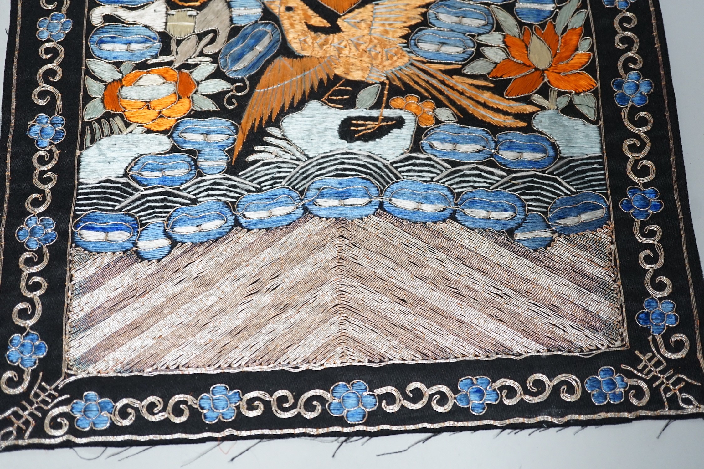Two Chinese 20th century Chinese rank badges, embroidered I’m metal and coloured silk threads on a black ground, with a central Phoenix surrounded by auspicious symbols, 27cms x 25cms